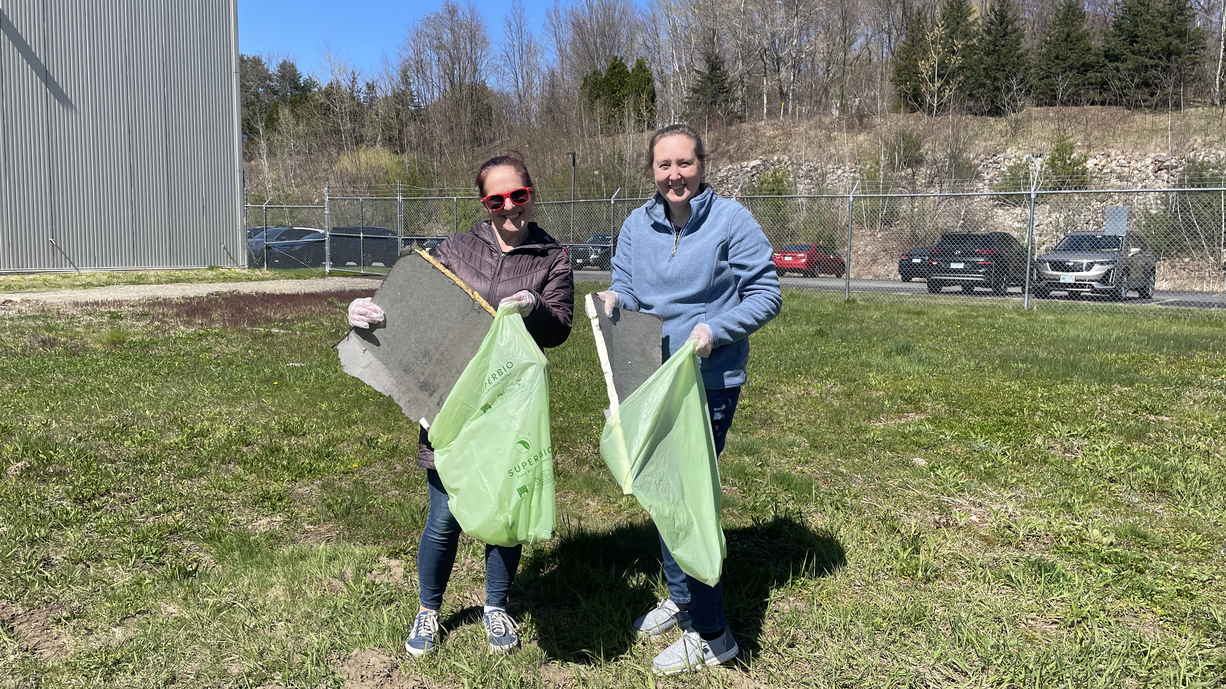 A group of people standing in a parking lot with of waste.