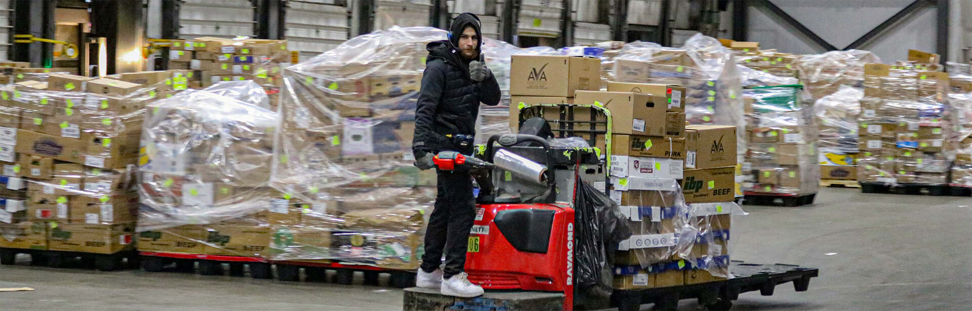 Worker driving a forklift in an AGNE warehouse.