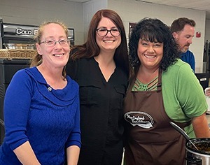 Three woman serving hotdogs