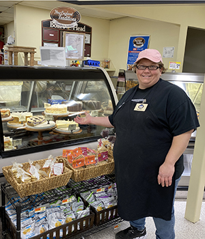 A bakery employee in front of a display case